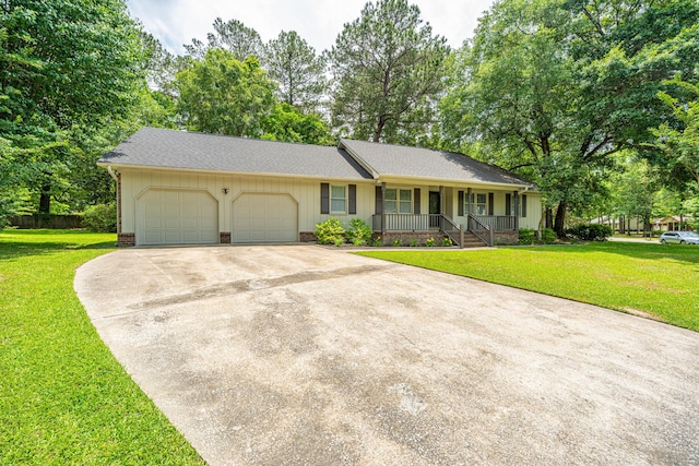 ranch-style home with a porch, a garage, concrete driveway, a front yard, and a shingled roof