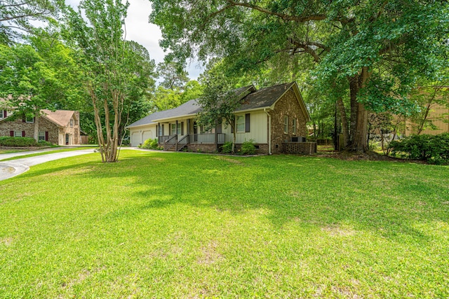 view of front of home with an attached garage, concrete driveway, a porch, and a front lawn