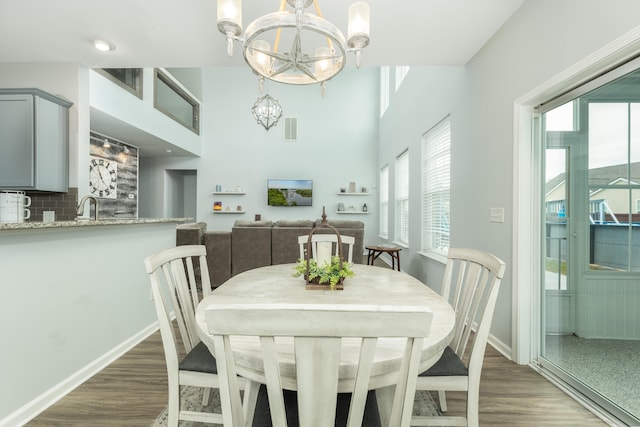 dining room with an inviting chandelier, dark hardwood / wood-style flooring, and sink