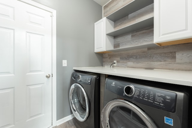 laundry room featuring washing machine and dryer and cabinets