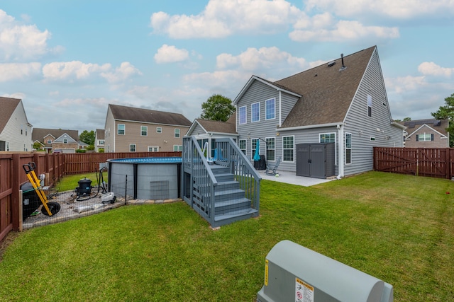 back of property with a fenced in pool, a patio area, and a lawn