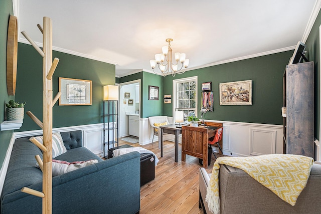 interior space featuring a wainscoted wall, ornamental molding, light wood-style flooring, and a notable chandelier