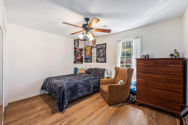 bedroom with wood-type flooring, baseboards, and a ceiling fan