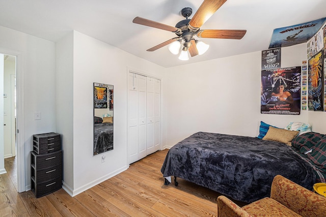 bedroom featuring light wood-style floors, a ceiling fan, baseboards, and a closet