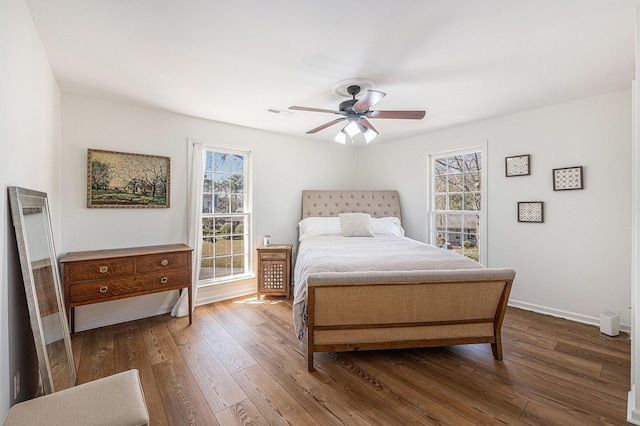 bedroom with a ceiling fan, multiple windows, hardwood / wood-style flooring, and baseboards