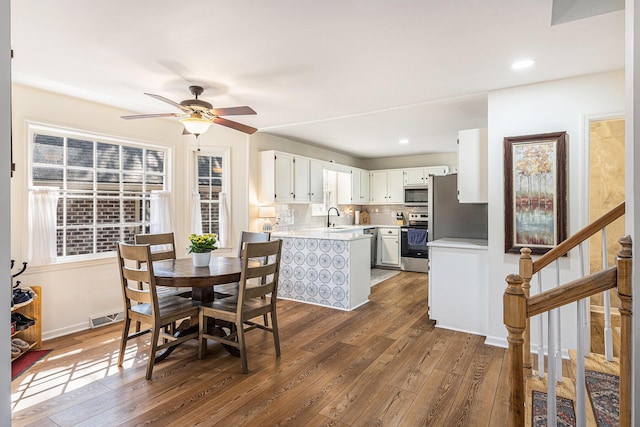 dining space with visible vents, ceiling fan, dark wood-style flooring, stairs, and recessed lighting