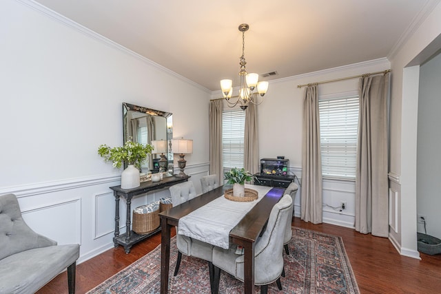 dining space with crown molding, a notable chandelier, wainscoting, wood finished floors, and visible vents