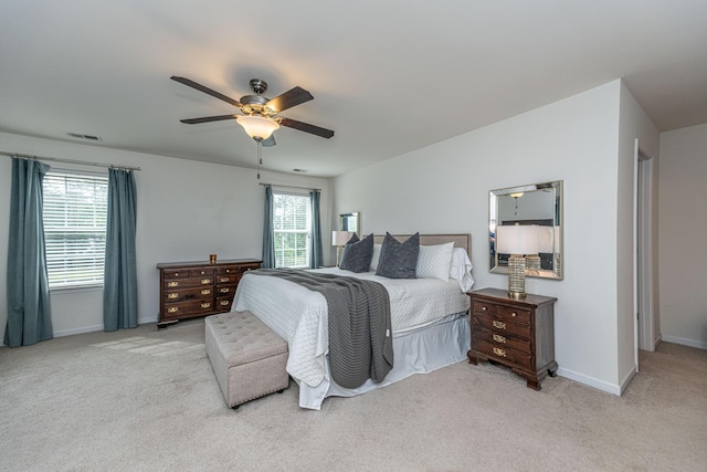 carpeted bedroom with baseboards, a ceiling fan, and visible vents