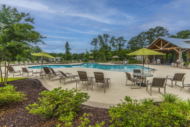 pool with a gazebo, fence, and a patio area
