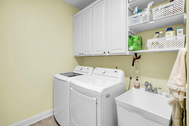 laundry room featuring cabinets, light tile patterned floors, washing machine and dryer, and sink