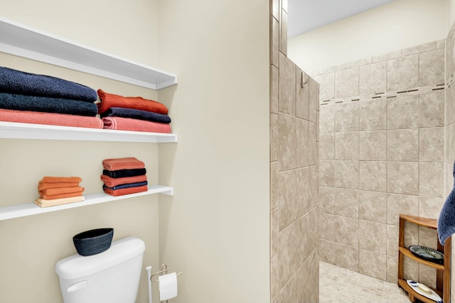 bathroom with toilet and tiled shower