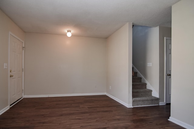 unfurnished room featuring a textured ceiling and dark wood-type flooring