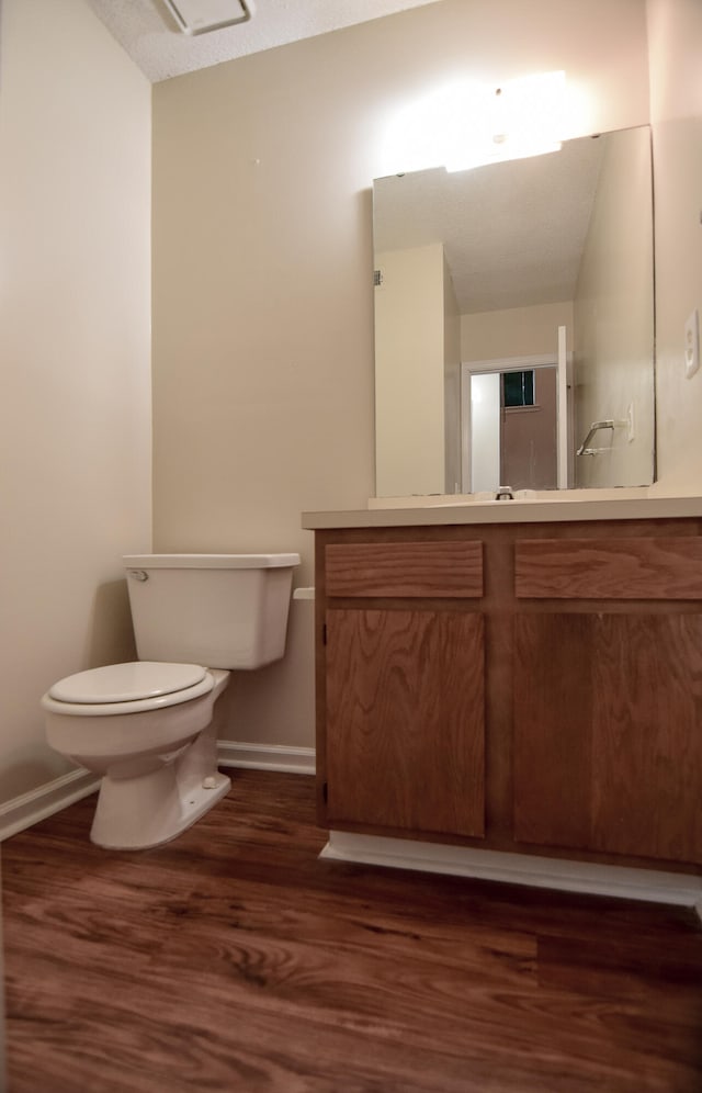 bathroom with vanity, hardwood / wood-style floors, and toilet