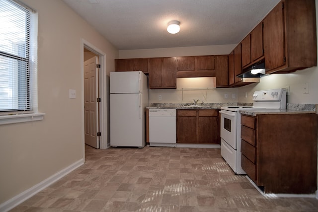 kitchen featuring a textured ceiling, plenty of natural light, sink, and white appliances