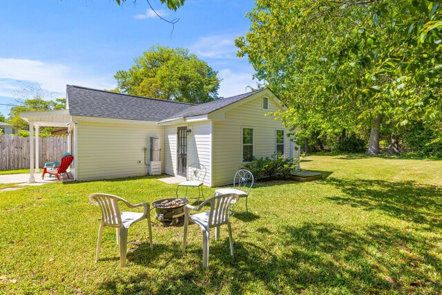 1324 Maxwell St, North Charleston, SC 29405 - rear view of property featuring a fire pit, a yard, roof with shingles, and fence