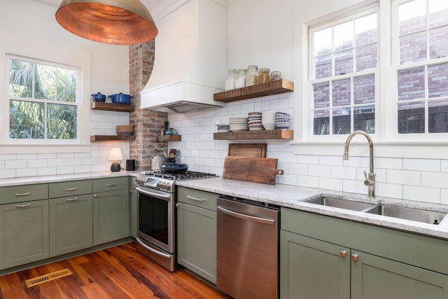 kitchen featuring custom exhaust hood, appliances with stainless steel finishes, decorative backsplash, dark wood-type flooring, and sink