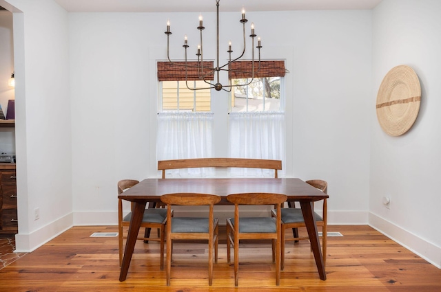 dining area with an inviting chandelier and hardwood / wood-style floors