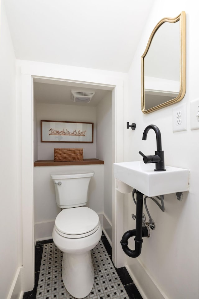 bathroom with toilet and tile patterned floors