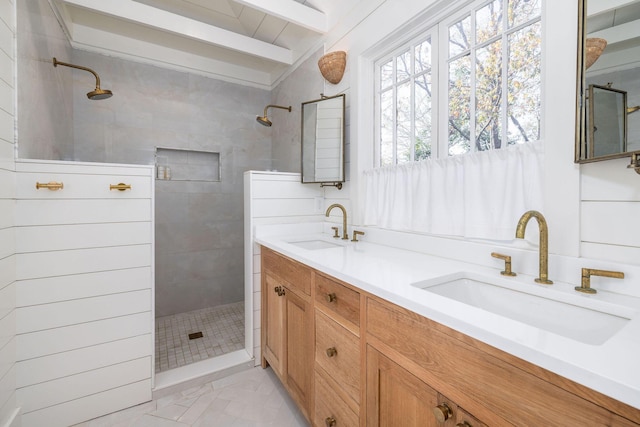 bathroom featuring tile patterned floors, tiled shower, vanity, and beamed ceiling