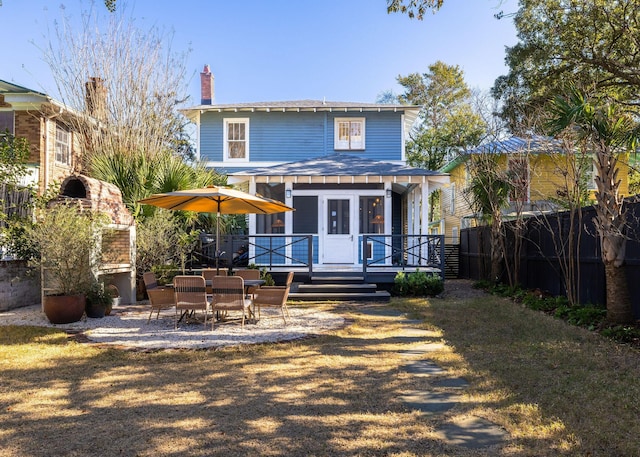 back of property with a yard and a wooden deck