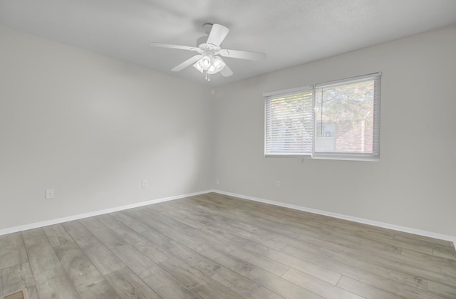 spare room with ceiling fan and light wood-type flooring