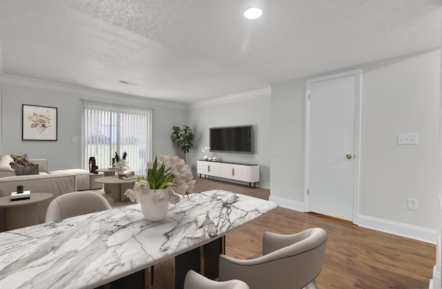 dining space featuring crown molding, dark wood-type flooring, and a textured ceiling