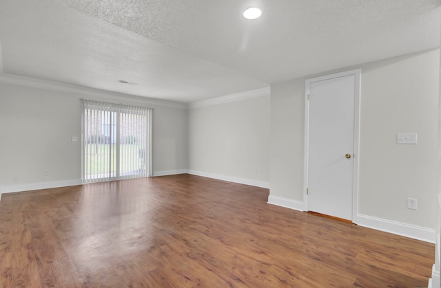 spare room featuring hardwood / wood-style floors, a textured ceiling, and crown molding