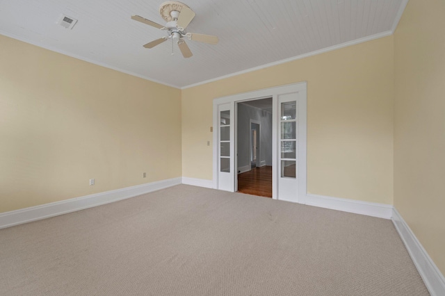 empty room with carpet, ceiling fan, french doors, and crown molding