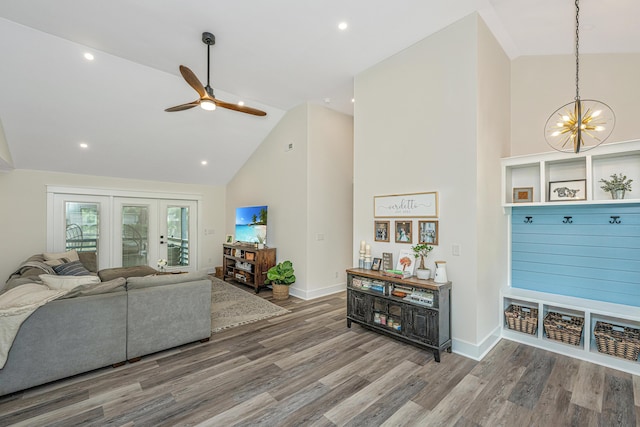 living room with high vaulted ceiling, hardwood / wood-style floors, and ceiling fan with notable chandelier