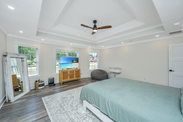 bedroom with a tray ceiling, ornamental molding, dark wood-type flooring, and ceiling fan