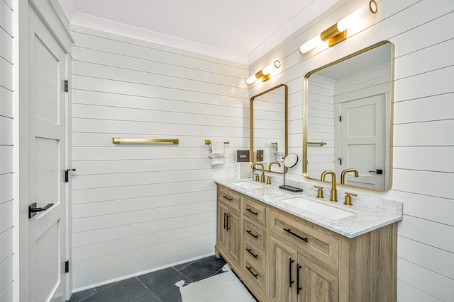 bathroom featuring tile floors, wooden walls, crown molding, and dual bowl vanity