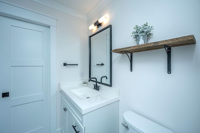 bathroom with oversized vanity, toilet, and crown molding