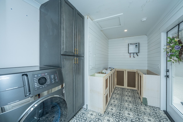 laundry room with wooden walls, washer / dryer, and light tile floors