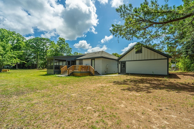 view of front of property featuring a sunroom, a front lawn, and a wooden deck