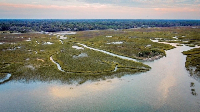 aerial view at dusk featuring a water view