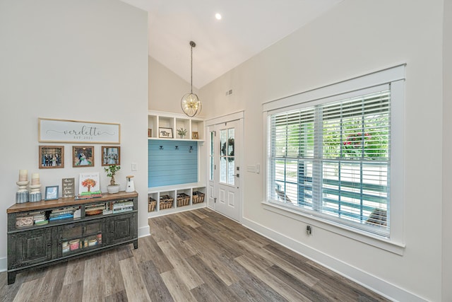 entryway with high vaulted ceiling, hardwood / wood-style floors, and a chandelier