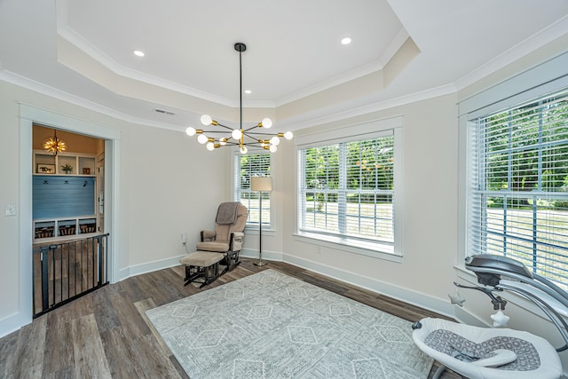 sitting room with a notable chandelier, a raised ceiling, dark hardwood / wood-style flooring, and ornamental molding