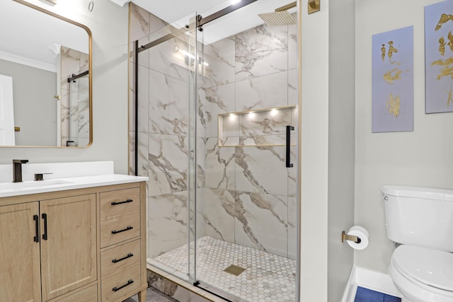 bathroom featuring vanity, toilet, a shower with door, and crown molding