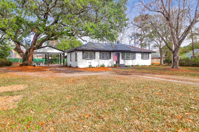 ranch-style home featuring a carport and a front yard