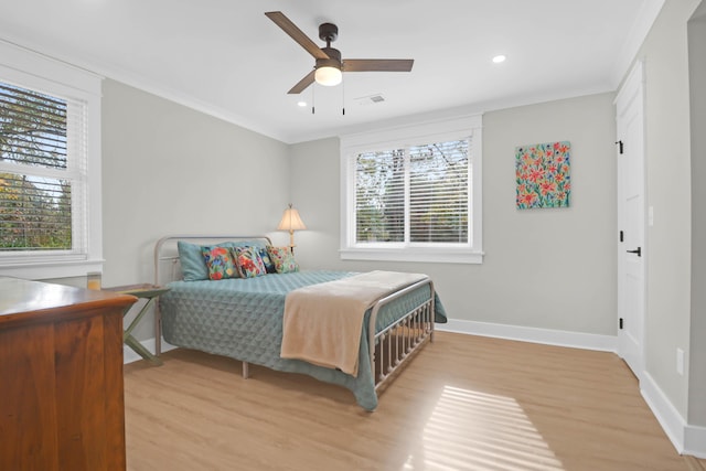 bedroom with multiple windows, ceiling fan, light hardwood / wood-style flooring, and crown molding