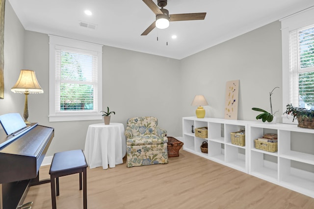 sitting room with ceiling fan, a healthy amount of sunlight, and light wood-type flooring