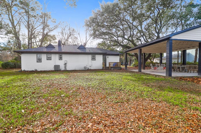 rear view of house with a lawn, central AC unit, and a patio