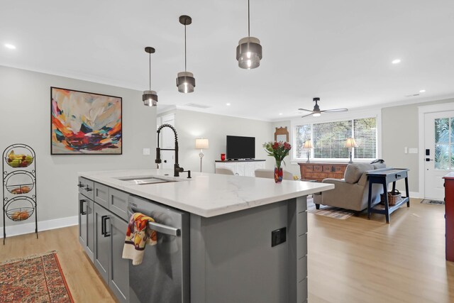 kitchen with ceiling fan, sink, stainless steel dishwasher, decorative light fixtures, and a kitchen island with sink