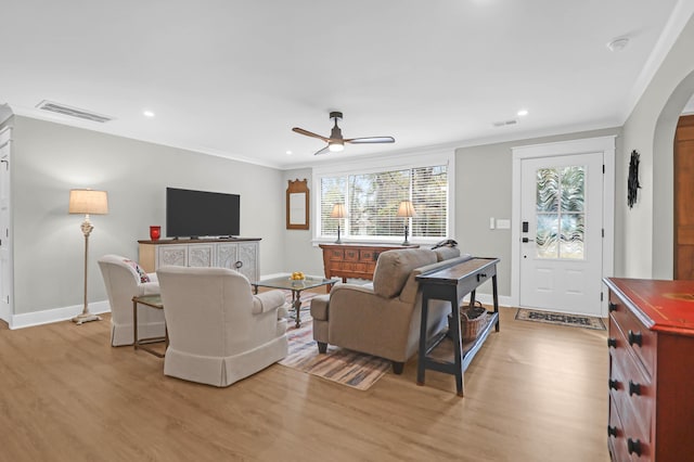 living room with light wood-type flooring, ceiling fan, and crown molding