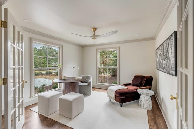 sitting room featuring hardwood / wood-style flooring, a wealth of natural light, ornamental molding, and ceiling fan