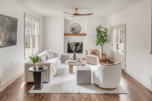 living room featuring ceiling fan, dark wood-type flooring, and a wealth of natural light