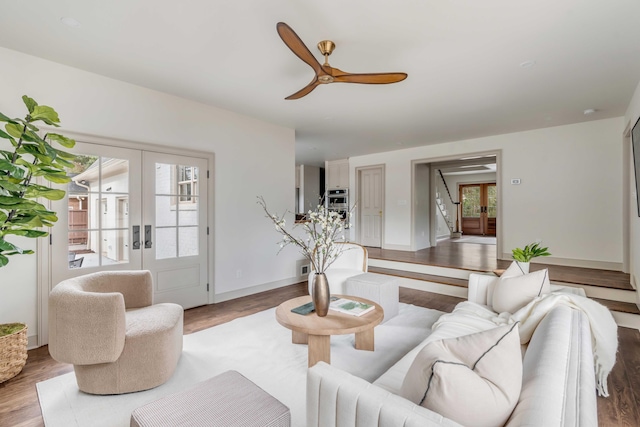 living room featuring french doors, ceiling fan, and wood-type flooring