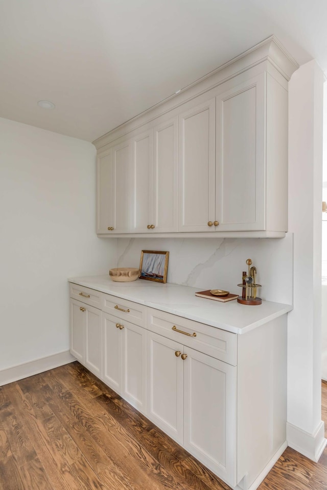 bar featuring dark hardwood / wood-style floors and white cabinetry