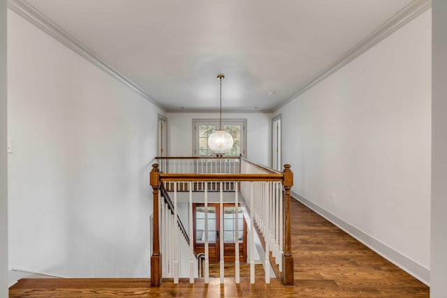 stairs with hardwood / wood-style floors, a chandelier, and ornamental molding