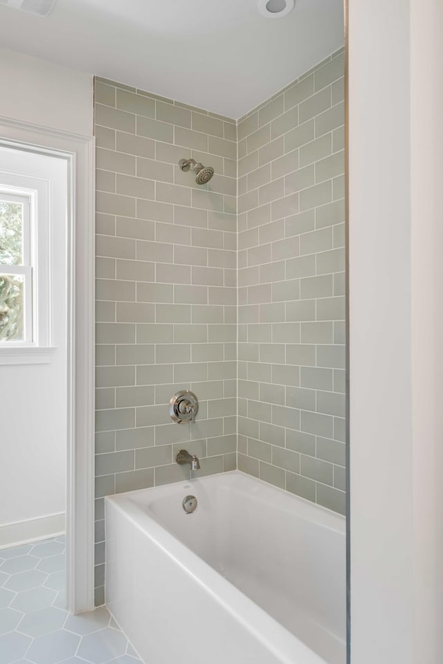 bathroom with tile patterned floors and tiled shower / bath